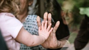 Grandparent_Child_Hands_Window_1296x728-header-1296x729