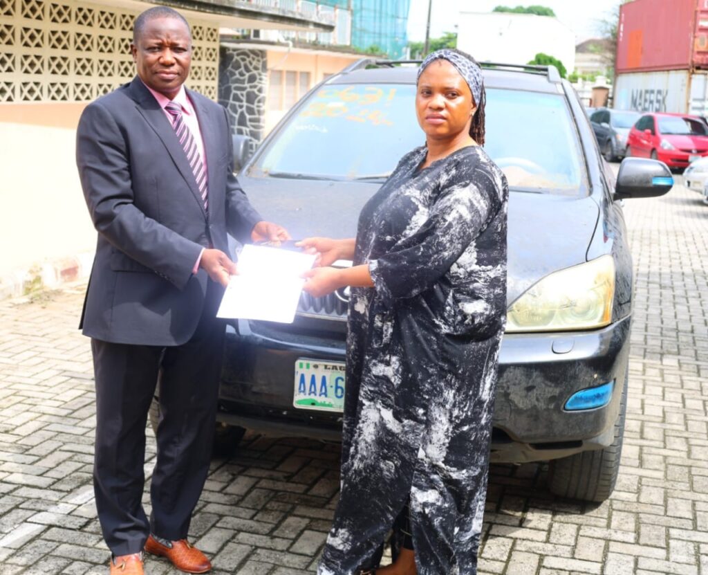 *EFCC officer handing over recovered assets to the Australian victim's lawyer, Blessing Nwankwo, on Wednesday, 15 July 2026.